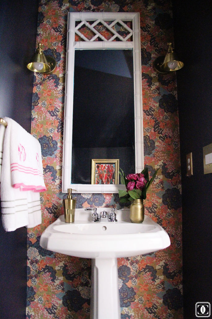 floral wallpaper, brass lighting, monogram towels, bamboo mirror 