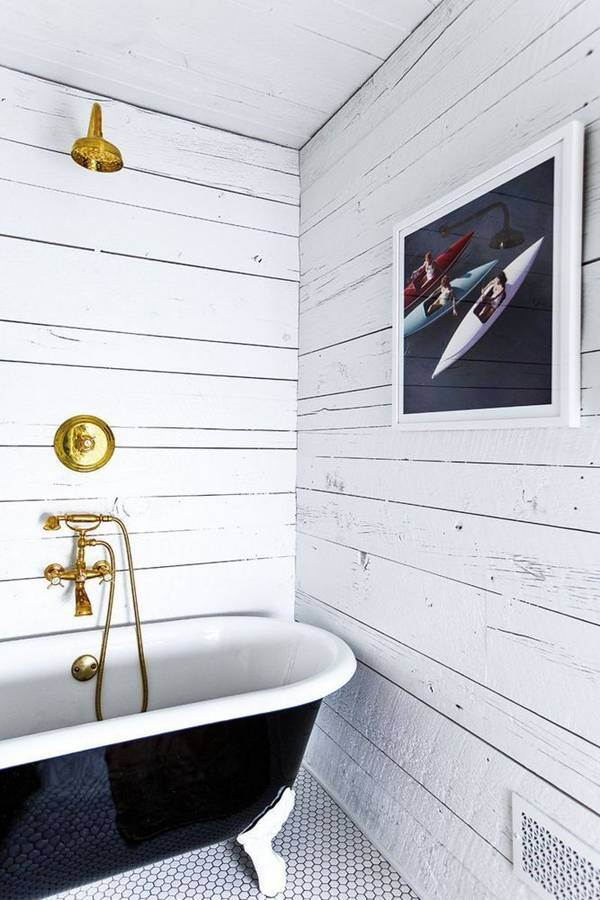 The shiplap walls in this bathroom add the perfect mix of rustic to the glam gold fixtures.