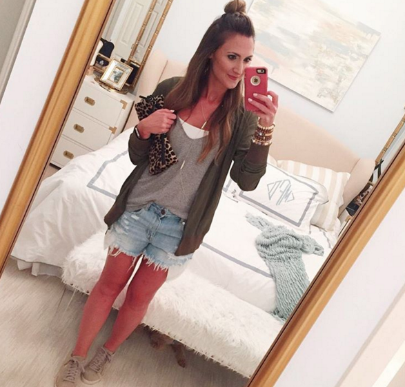 Green bomber jacket with denim shorts for a causal outfit