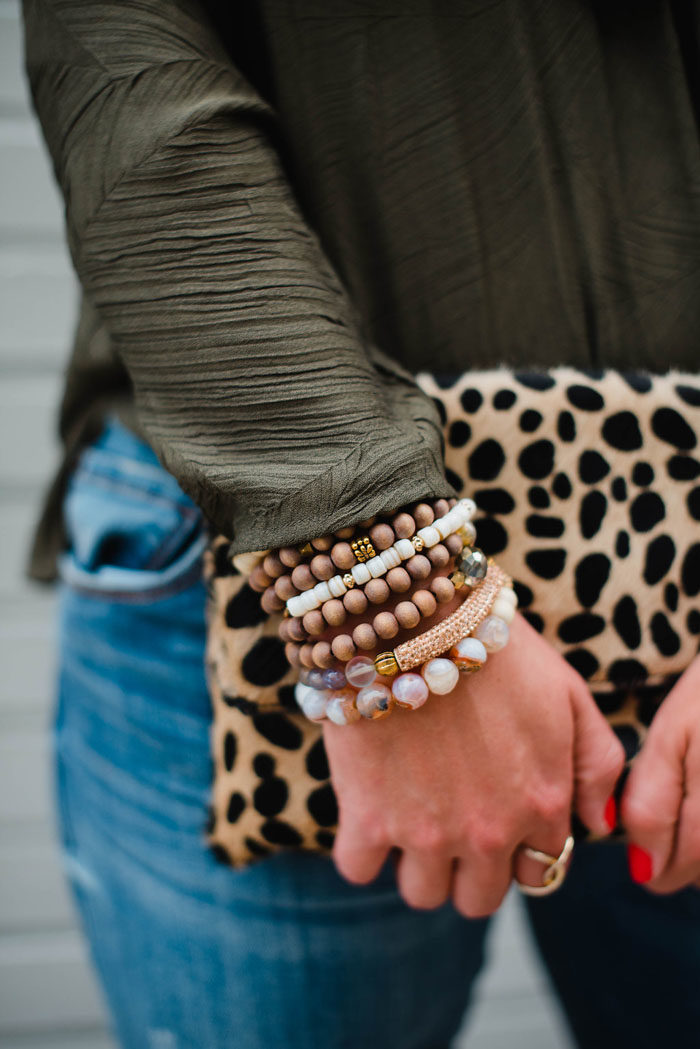 Cooper and Ella crossover top styled with beaded bracelets and a cheetah clutch