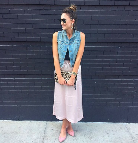Pink silk skirt paired with a denim vest for a girly and glam look that's still comfortable.