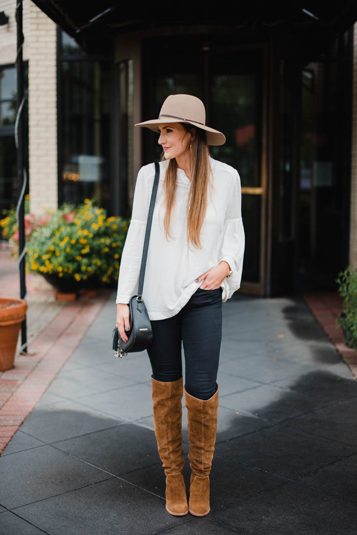 Blogger Mallory Fitzsimmons of Style Your Senses wears a Free People bell sleeved blouse, over the knee boots and tan felt hat.