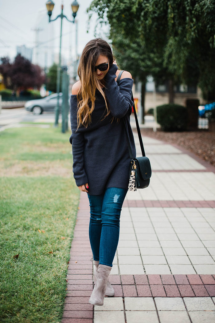 Blogger Mallory Fitzsimmons of Style Your Senses wears an off the shoulder sweater and grey mid calf booties for a transitional outfit.