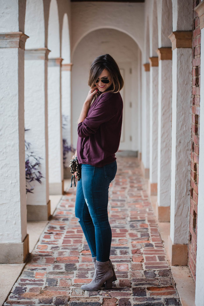 Blogger Mallory Fitzsimmons of Style Your Senses is wearing a merlot wrap front sweater and distressed skinny jeans for a Fall casual outfit that's chic and comfortable