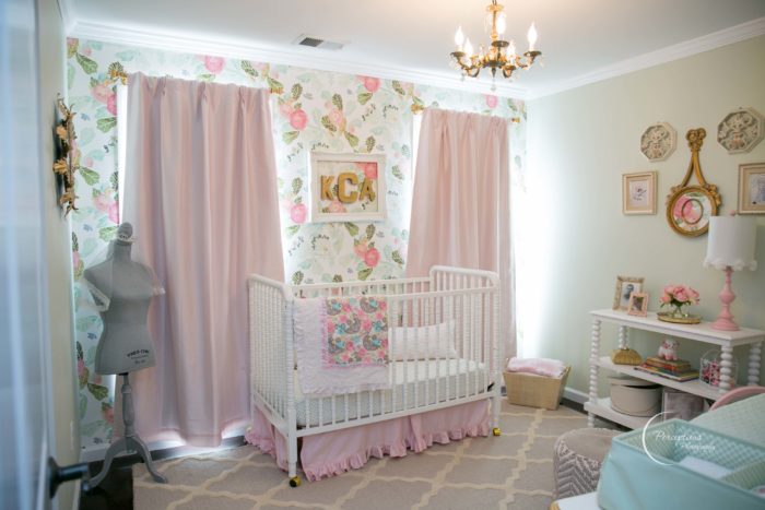 Beautiful baby girl nursery with pink drapes, floral wallpaper, classic Jenny Lind crib and trellis rug