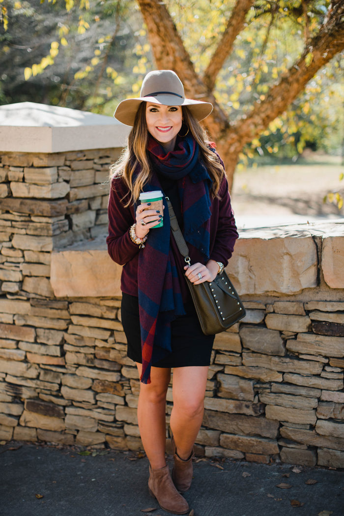Blogger Mallory Fitzsimmons of Style Your Senses wears a black body con dress with a large blanket scarf , felt hat and cross body Rebecca Minkoff bag for a transitional Fall outfit