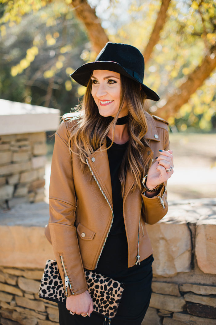 Blogger Mallory Fitzsimmons of Style Your Senses wears a black body con dress with a gorgeous leather moto jacket, felt hat and choker for a dressed up Fall transition look.