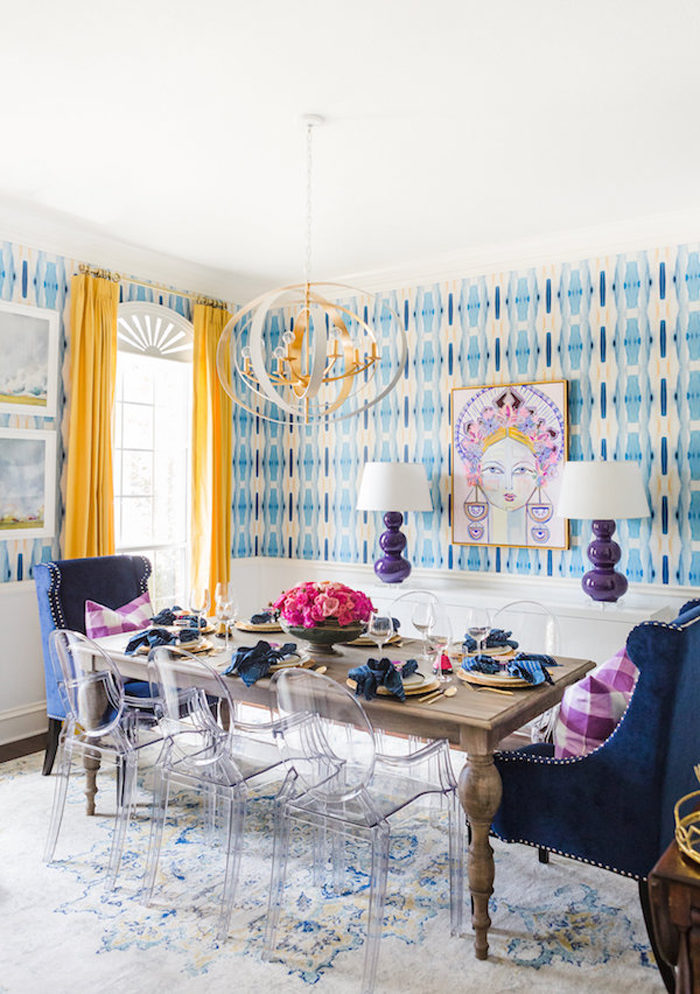 Gorgeous dining room with bold wallpaper, yellow drapes, and custom artwork