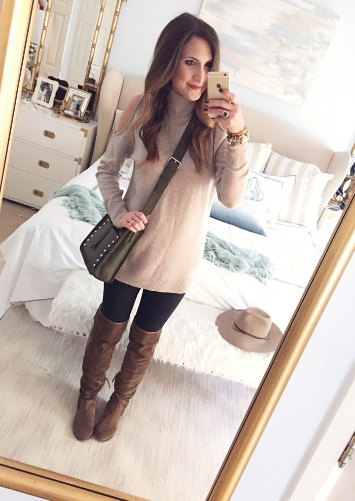 Blogger Mallory Fitzsimmons of Style Your Senses wears a cold shoulder tunic sweater with a large statement necklace, skinny jeans and over the knee boots for a festive Thanksgiving outfit idea