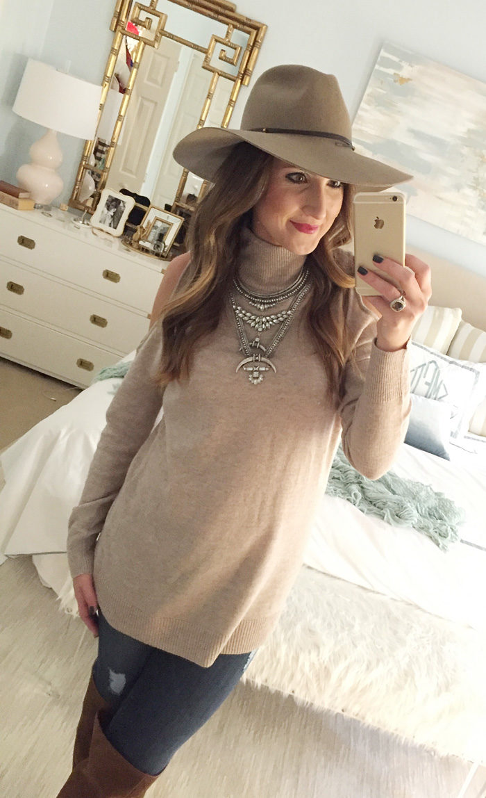 Blogger Mallory Fitzsimmons of Style Your Senses wears a cold shoulder tunic sweater with a large statement necklace, skinny jeans and over the knee boots for a festive Thanksgiving outfit idea