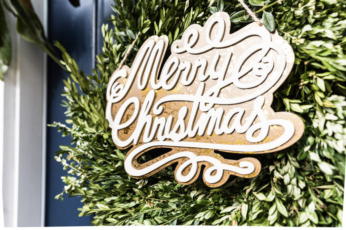 Blogger Mallory Fitzsimmons of Style Your Senses shares her Holiday Home Tour that includes this boxwood front door wreath with wooden Merry Christmas sign - Our Holiday Home Tour featured by popular Texas lifestyle blogger, Style Your Senses