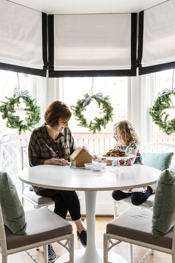 Holiday Home Tour 2016 decorating a gingerbread house in breakfast nook - Our Holiday Home Tour featured by popular Texas lifestyle blogger, Style Your Senses
